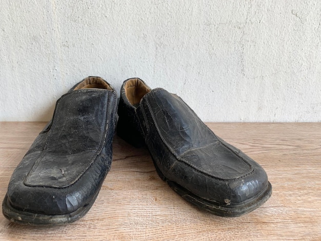 Close up retro old vintage leather shoe put on wooden table top