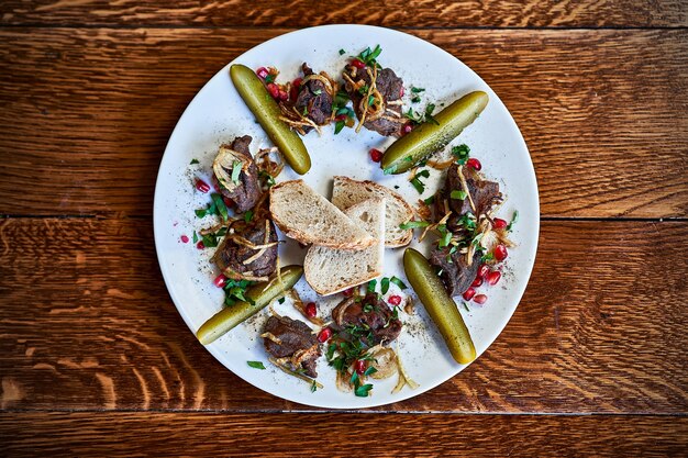 Close up of roasted beef liver with pickle on plate