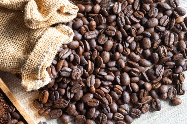 close up Roasted coffee beans in small sack  on wooden table