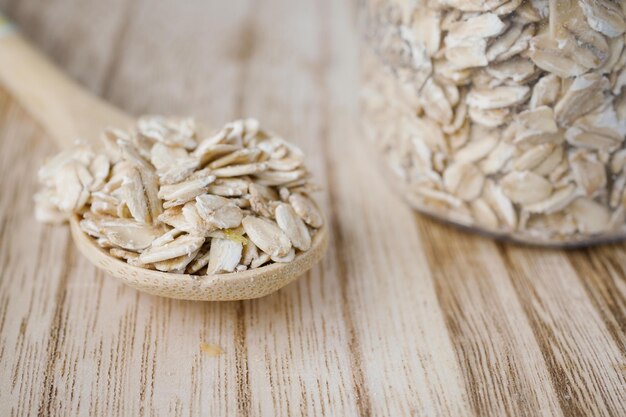 Close up of roasted oats flakes on spoon on table