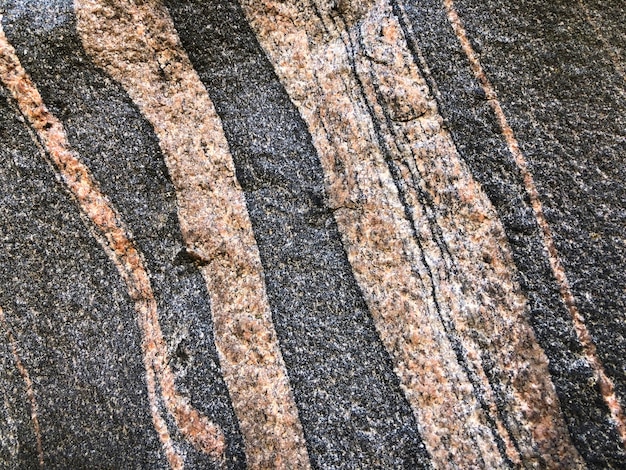 Close up of rock with pink and gray striped pattern Stone background rock texture geology ornament