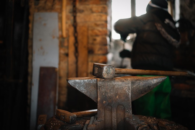 Close-up of rusty hammer and anvil in blacksmith workshop