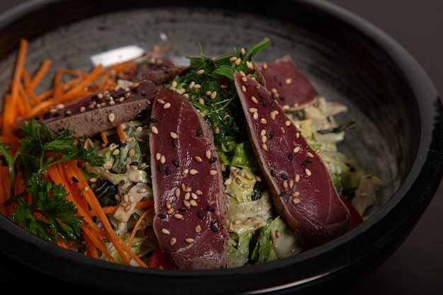 Close up of the salad bowl with tuna tataki. Asian cuisine