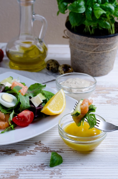 Close up on salad on fork dipped in sauce