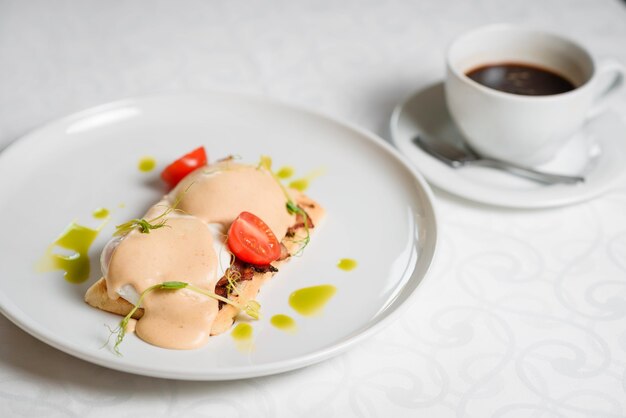 Close-up of sandwich on white dish with a cup of coffee