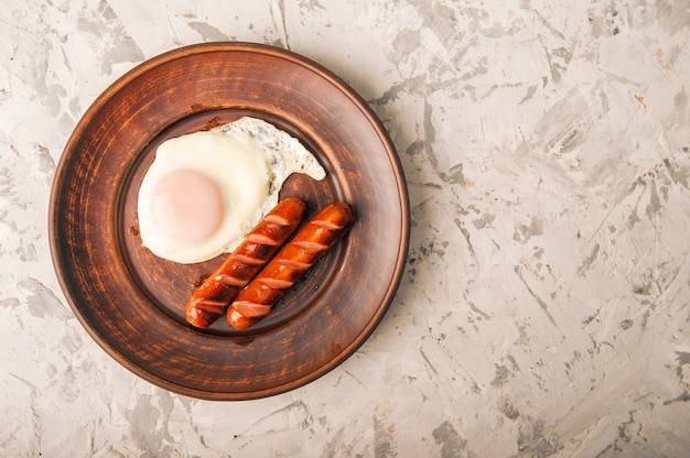 Close-up of sausages and fried eggs. Sausages on a plate and place for text.