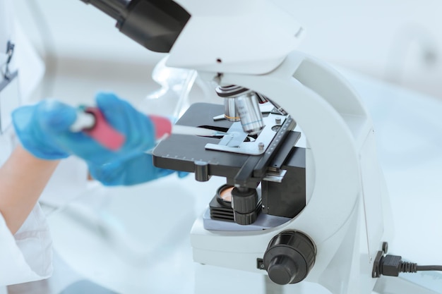 Close up scientist analyzing microscope slide at laboratory