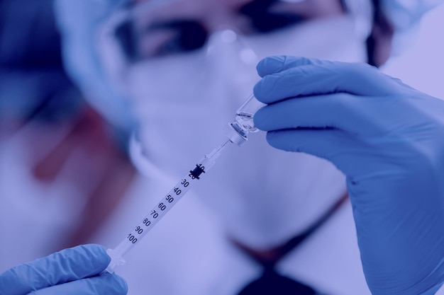 Close up scientist filling the syringe with the new vaccine