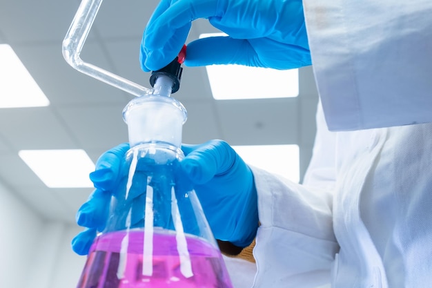 Close up scientist uses a titration method of analysis to study the chemical properties of the water...