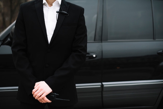 Close-up security guard in front of car