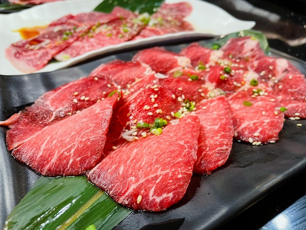 Close up and selective focus raw fresh beef slice on plate at restaurant.