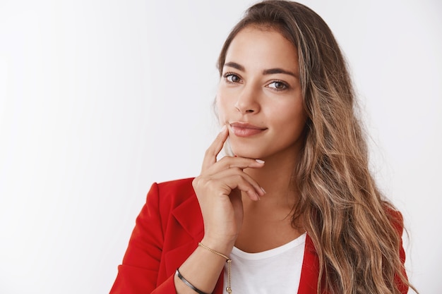 Close-up self-assured successful rich businesswoman wearing red jacket touching jawline smiling confident looking camera smart intelligent, know how maintain business attract customers