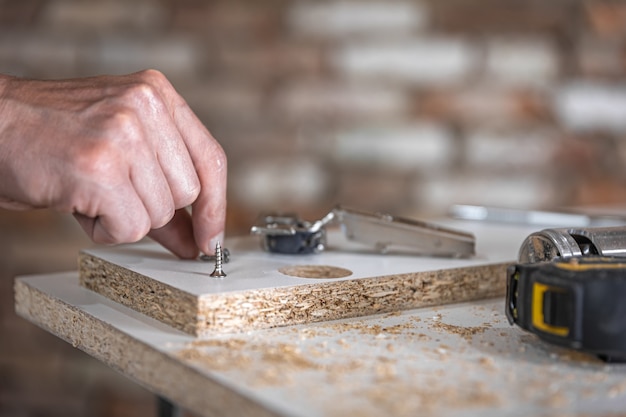 Close-up of self-tapping screw, wood screw on blurred background.