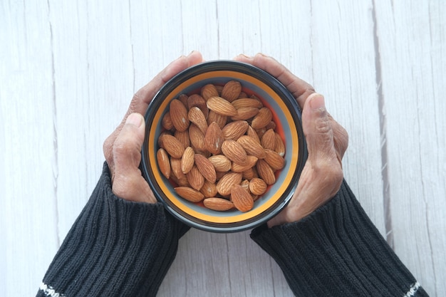 close up senior women hand holding a bowl on almond