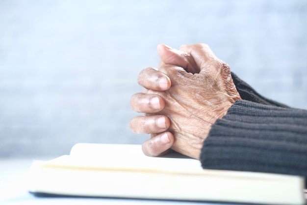 Close up of senior women hand praying at.