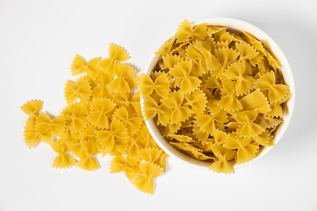 Close up of several types of dry pasta in a plate on white background