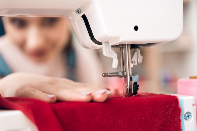 Close up sewing machine makes a new dress.