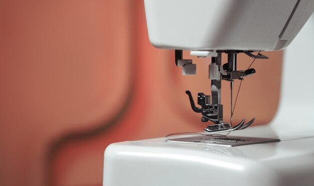 Close up on Sewing machine needle mechanism in red walls tailor shop