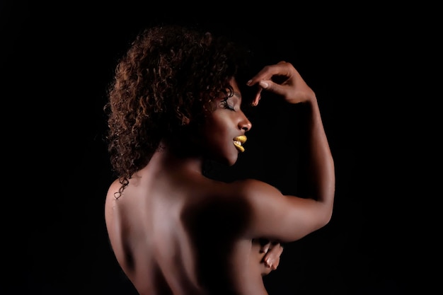 Photo close-up of shirtless young woman against black background