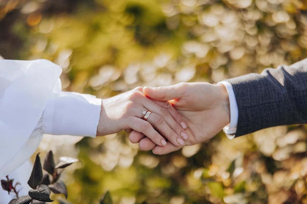 Close up shot of a bride and grooms hands interlocked