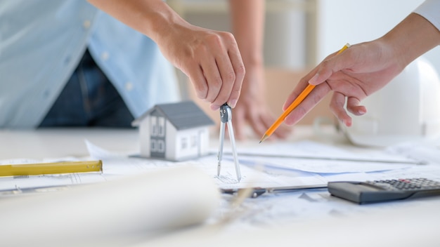 Photo close-up shot of designers are using the equipment to draw house drawings.