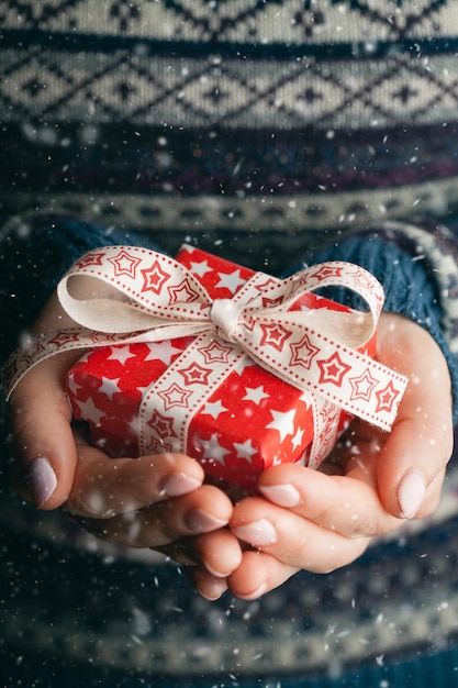 Close up shot of female hands holding a small gift Shallow depth of field with focus on the little box