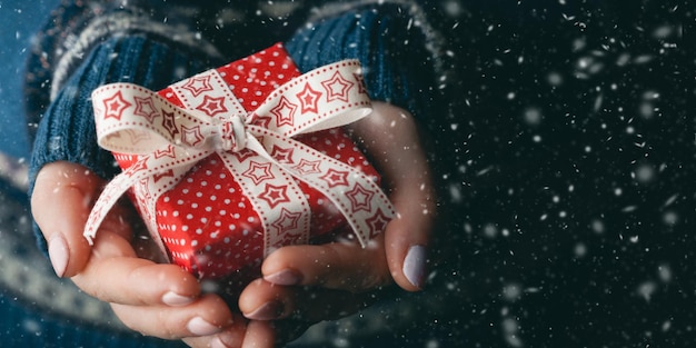 Close up shot of female hands holding a small gift Shallow depth of field with focus on the little box