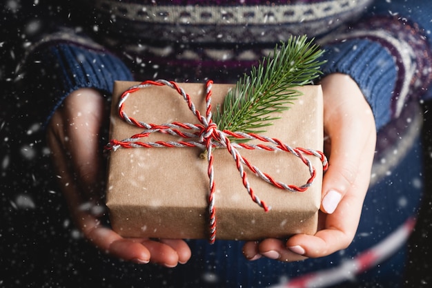 Close up shot of female hands holding a small red gift