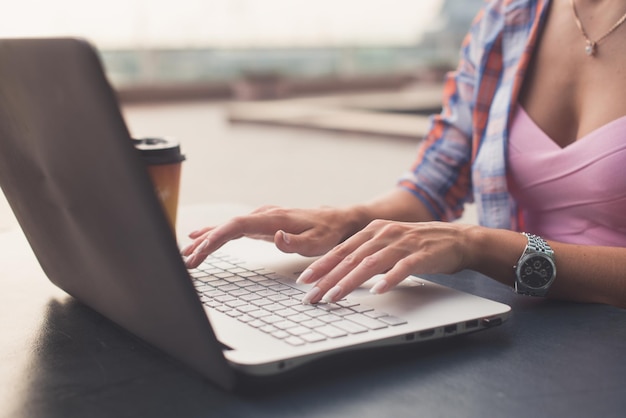 Close up shot of female hands typing on a laptop keyboard