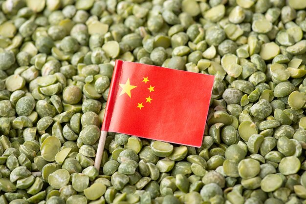 Close up shot of flag of China on green pea Concept of growing pea in China