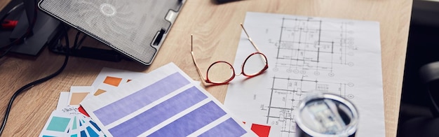 Photo close up shot of glasses architectural blueprint with papers and color samples thermos flask on