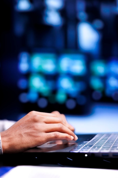 Close up shot of manager in server hub using laptop to set up configuration management tools that enable automatic failover and load balancing, preventing rackmounts data loss