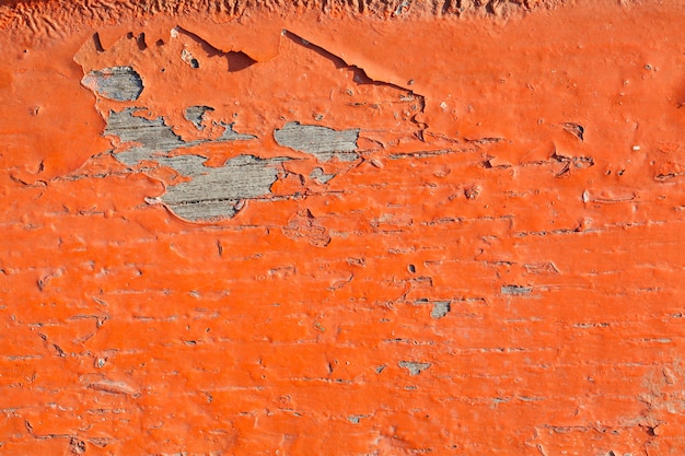 Close up shot of old orange paint texture peeling off wood plank background