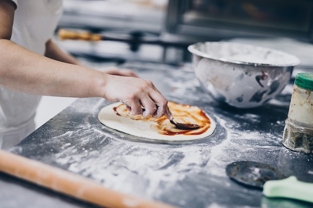 Close up shot of pizza making or preparing process.