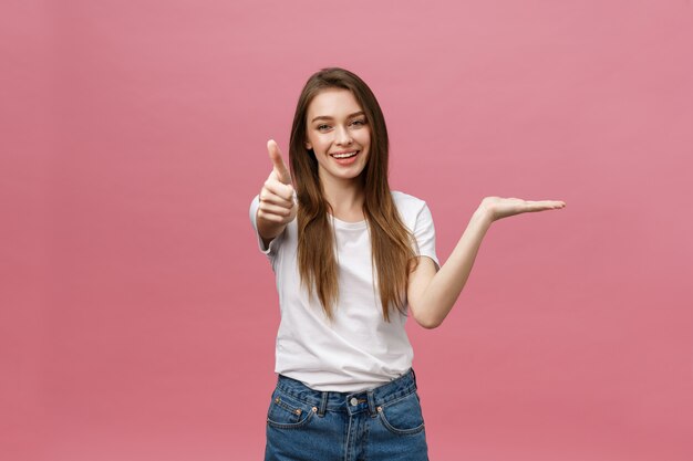 Close-up shot of smiling pretty girl showing thumb up gesture