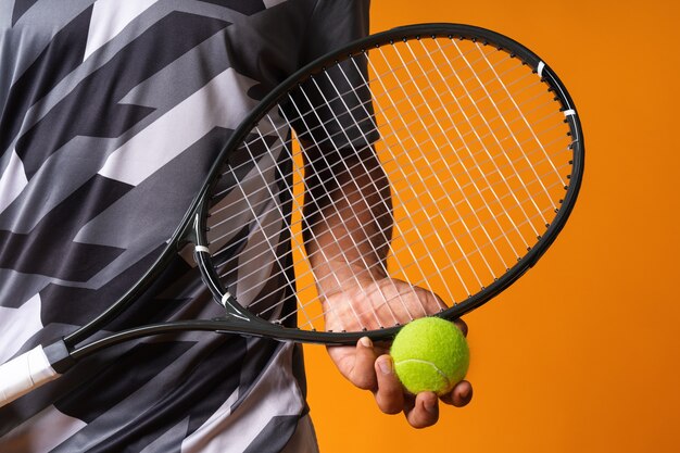 Close up shot of a tennis player hand with tennis racket and ball