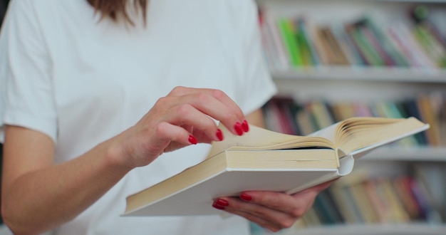 Close up shot of unrecognizable woman student reading book searching for information at university library Self education concept