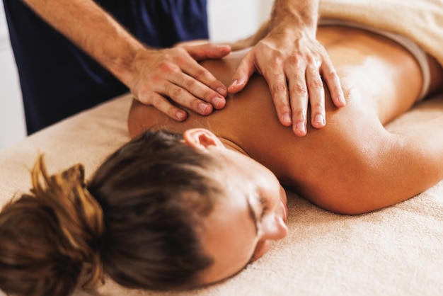 Close-up shot of a woman enjoying a relax back massage at the beauty salon.