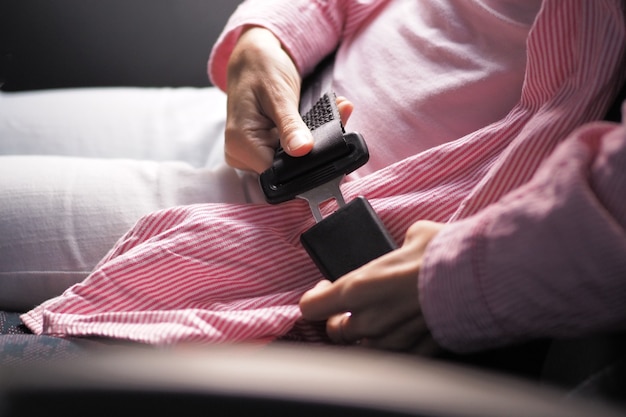 Close-up shot of a woman fastening her seat belt in public bus.