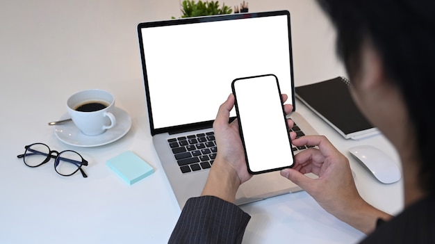 Close up over shoulder view of businessman using smart phone.