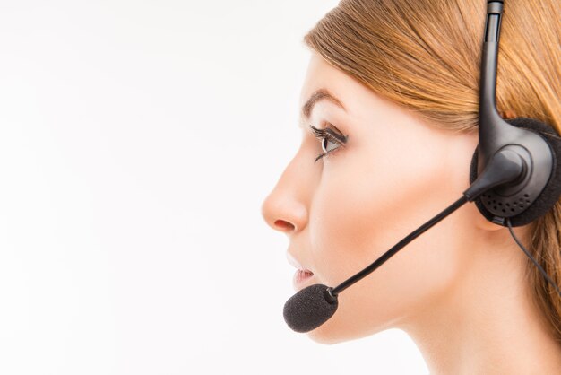 A close-up side-face portrait of a young agent of call centre