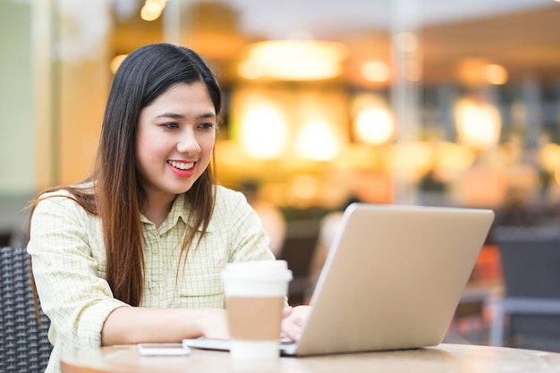 close up single asian student girl typing work or searching data information on notebook 