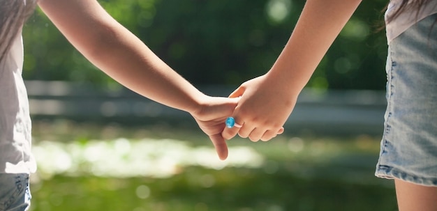 Close up of sister hold hand with small sister