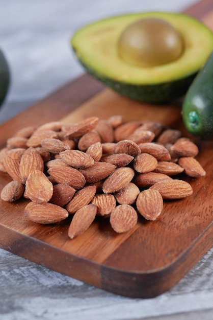 Close up of slice of avocado and almond nut on chopping board