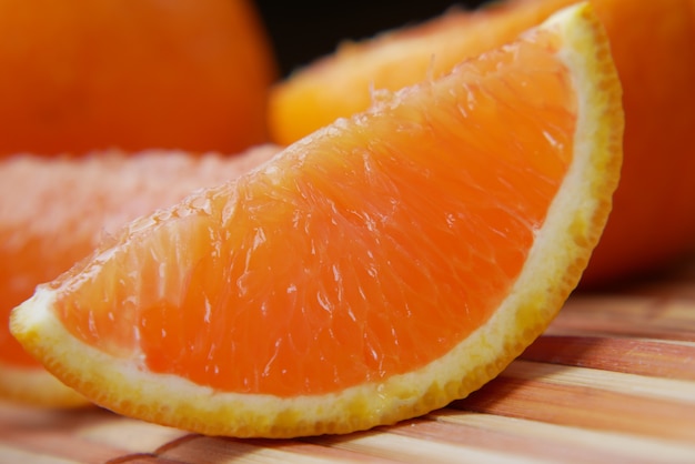 Close up of slice of orange fruit on color background