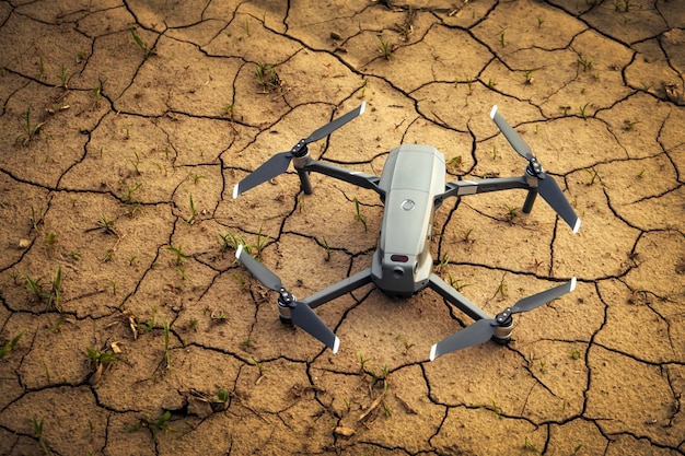 Close up small drone on brown soil in the field