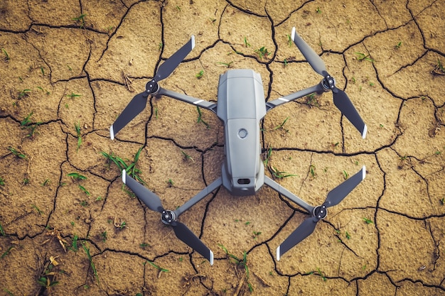 Close up small drone on brown soil in the field