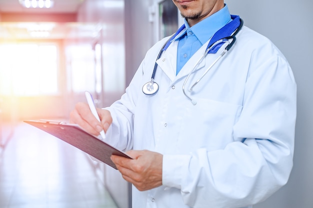 close up smiling male doctor. Young doctor with stethoscope in hospital hall