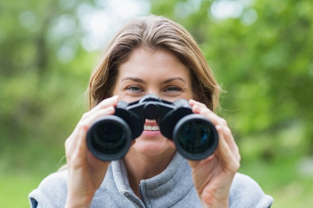 Close-up of smiling woman with binoculars 