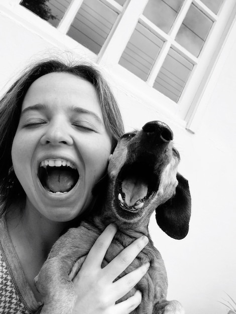 Photo close-up of smiling woman with mouth open holding dog